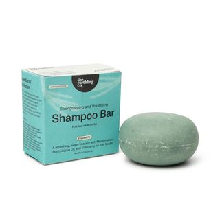 A shampoo bar by The Earthling Co. next to its box