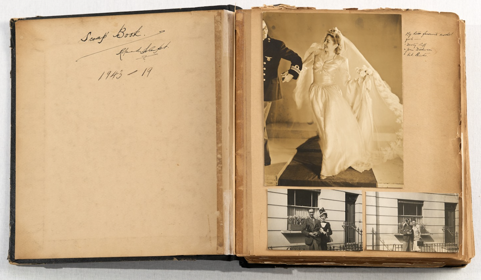 A worn scrapbook lies open; the left page bears the handwritten inscription "Scrap Book 1943" and the right page holds a large sepia photograph of a bride in a full veil alongside two smaller street photographs.