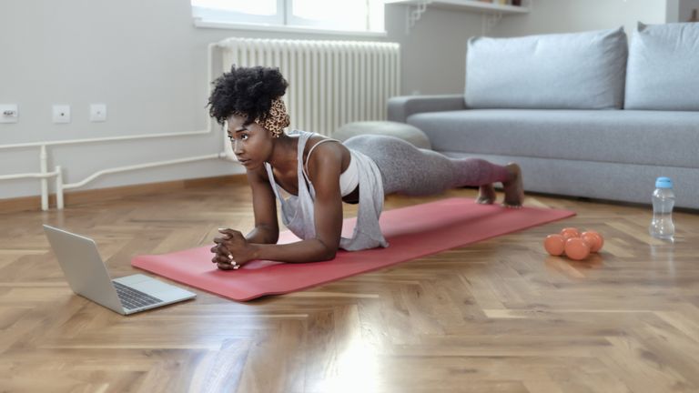 Determined Young African American Female in Sportswear Doing Plank Exercises in Her Spacious Living Room