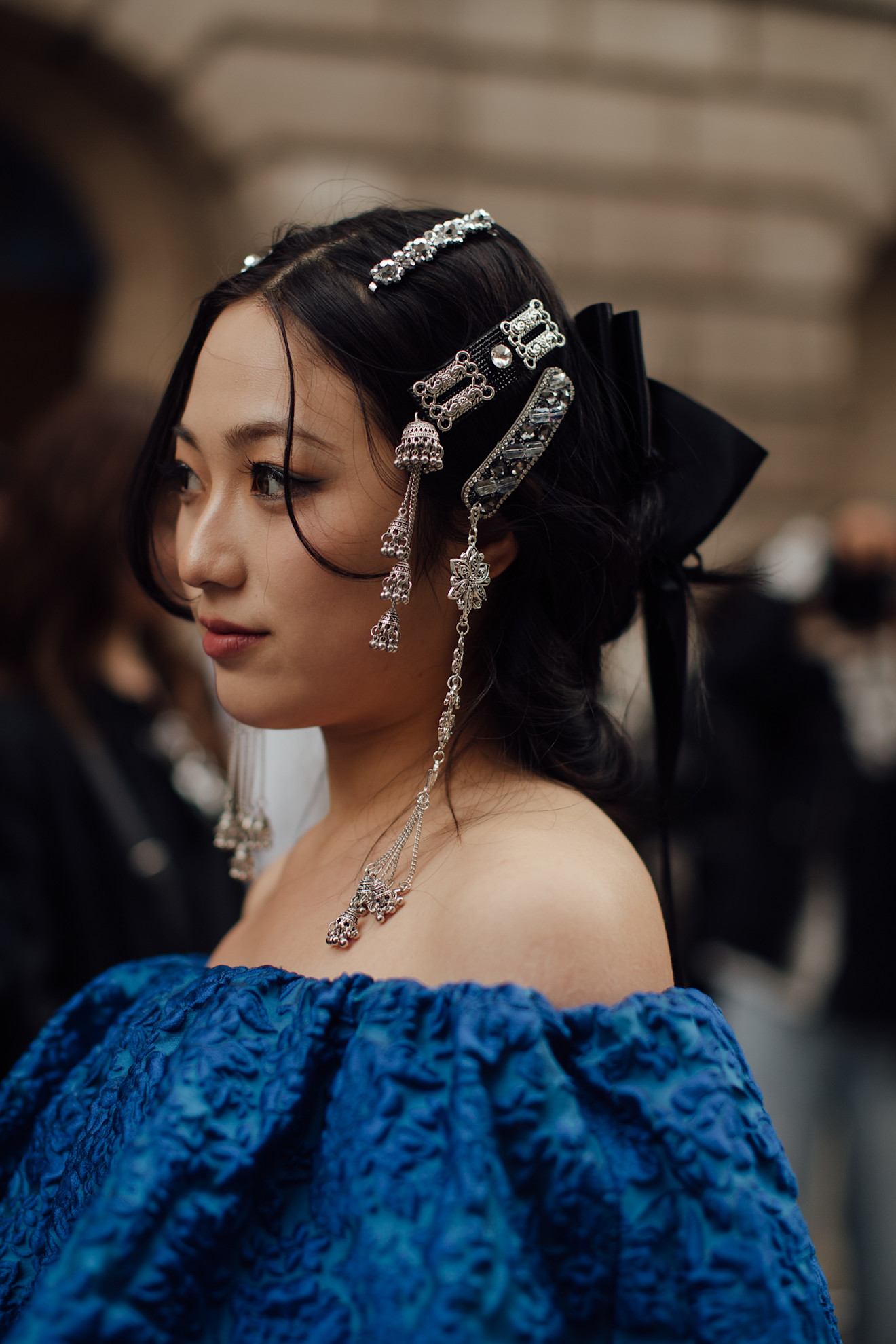 girl in a blue strapless top with a bunch of silver barettes in her hair