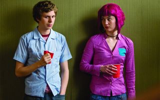(L to R) Michael Cera as Scott Pilgrim and Mary Elizabeth Winstead as Ramona Flowers stand next to each other in a hall in Scott Pilgrim vs the World