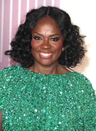 Viola Davis with her hair in a curly bob in a green dress.