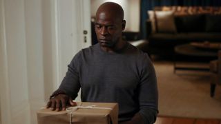 dembe looking at package on table in the blacklist