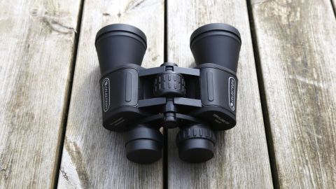 Image shows the Celestron UpClose G2 10x50 binoculars resting on a wooden surface.