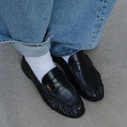 a close up of black leather saint laurent loafers