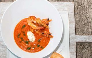 Spicy tomato and red pepper soup, seared prawns, olive oil and chives