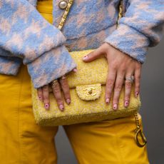 street style shot of woman with yellow bag and heart nail art