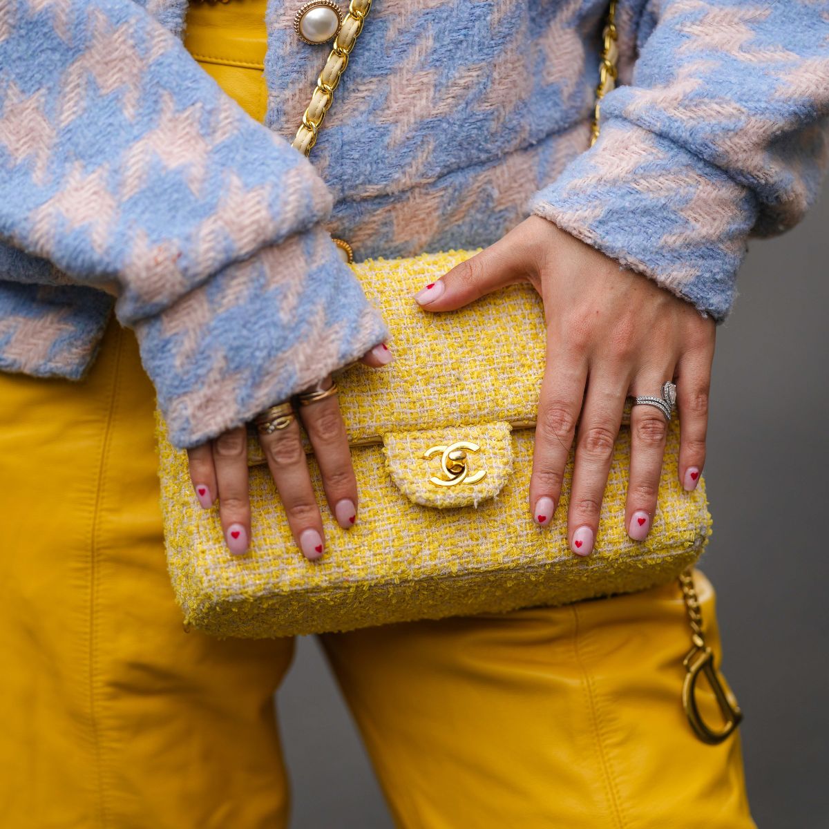 street style shot of woman with yellow bag and heart nail art