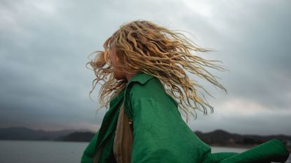 A girl dancing with wild hair in moody light
