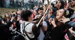 Yungblud joins the audience during a live performance, thrusting his Polaris White '64 Gibson SG into a crowd of ecstatic fans