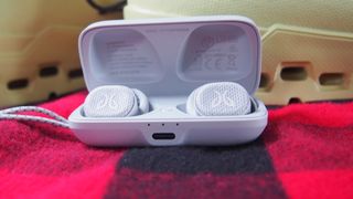 The jaybird vista 2 true wireless earbuds in their charging case on a red background