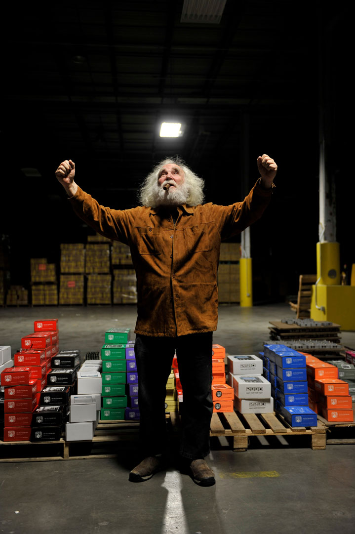 Mike Mathews, raising both fists in the air, in the Electro-Harmonix warehouse in 2013