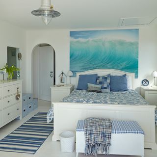bedroom with white wall painting on wall white floor and white bed