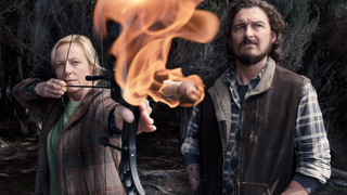 Anika Van Cleef (aka Stella Heikkinen) played by Marta Dusseldorp fires a flaming arrow in "Bay of Fires". Jeremiah, played by Toby Leonard Morore, looks on anxiously.