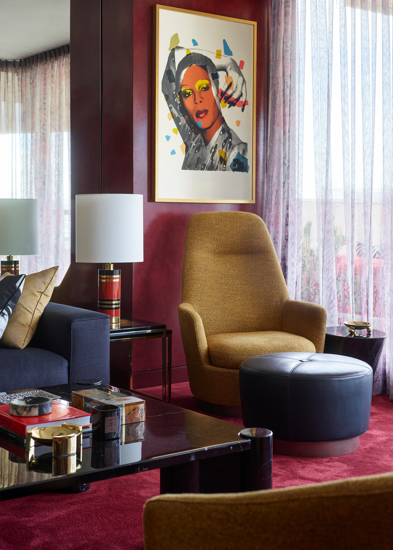 Greg Natale's apartment living room with red walls and carpet with a statement coffee table and artwork