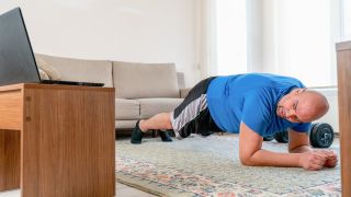 Man performs forearm plank at home