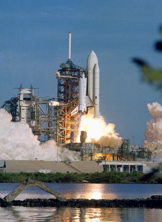 The space shuttle Columbia begins a new era of space transportation when it lifts off from NASA's Kennedy Space Center in Cape Canaveral, Fla, on April 12, 1981. The reusable orbiter, its two fuel tanks and two solid rocket boosters (SRB) has just cleared