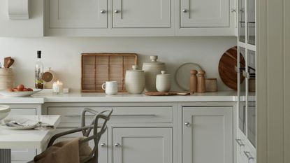 A white and cream kitchen with neutral and wooden decor on the counters
