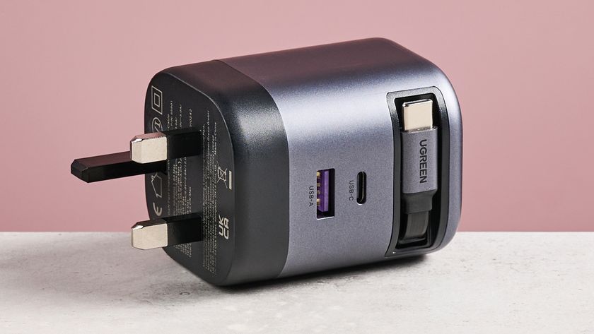 UGreen Nexode 65W Charger with Retractable USB-C Cable on its side against pink background