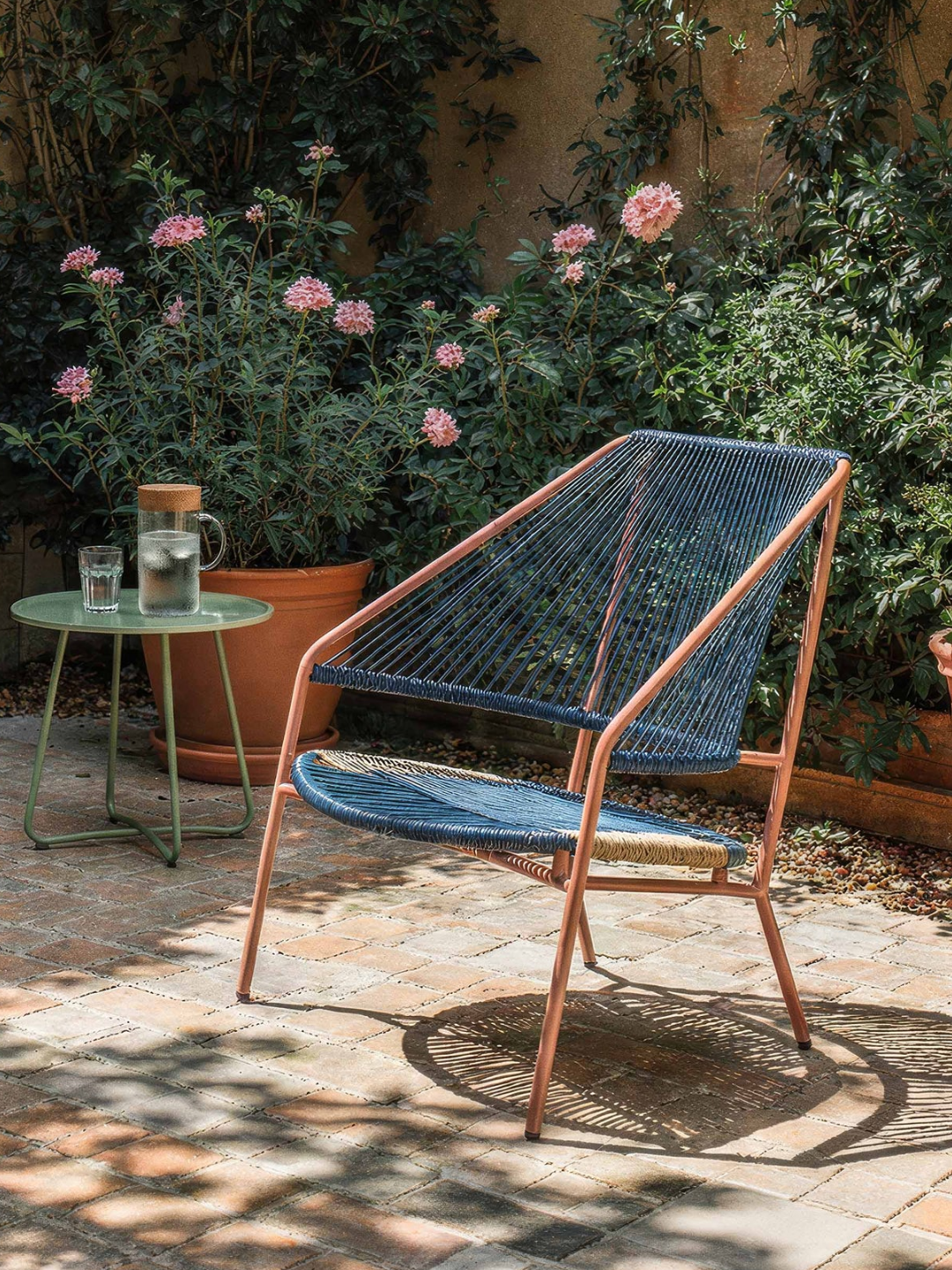 A woven armchair in a garden setting