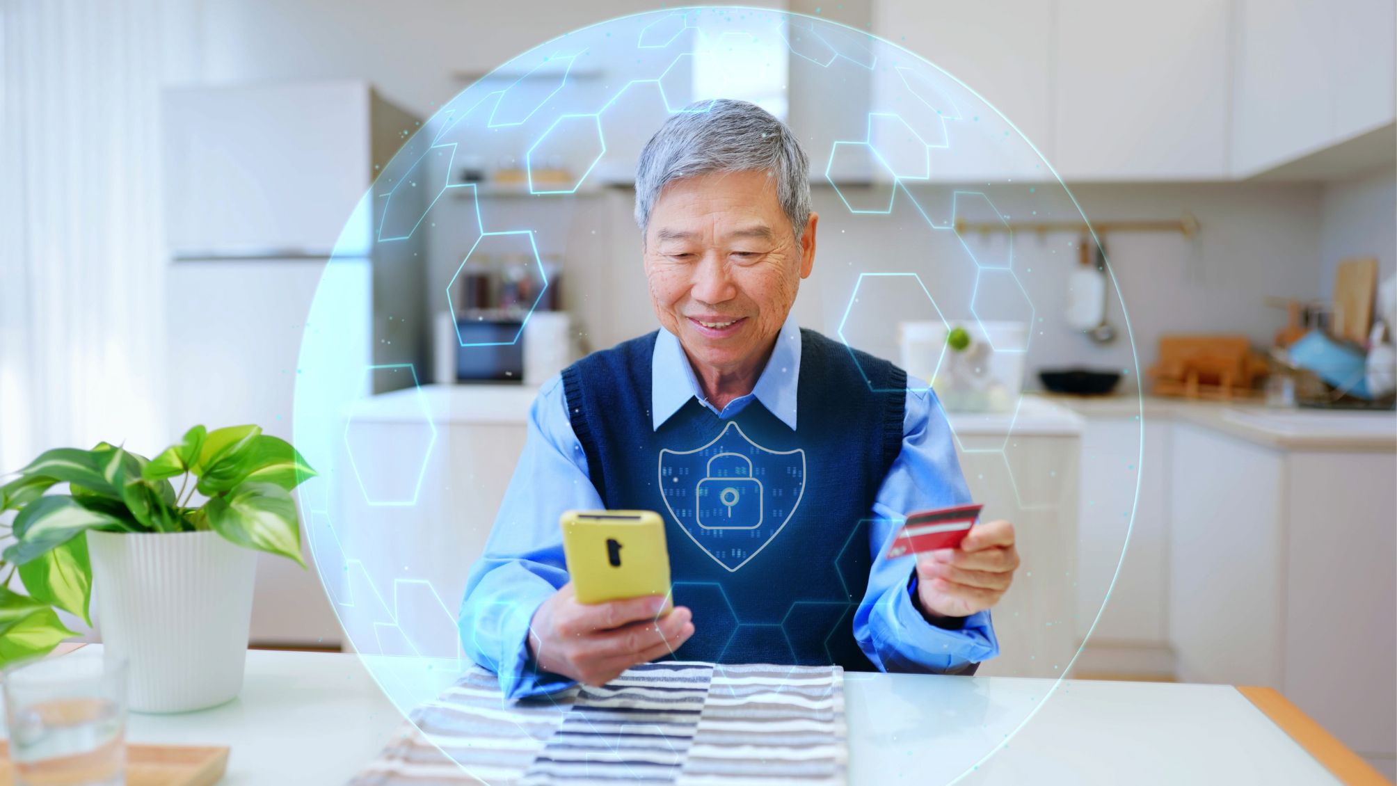 A man holds smartphone and credit card protected by a virtual security shield at home kitchen table