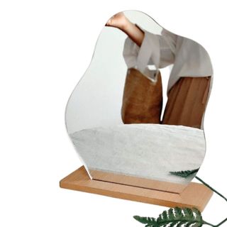 A wiggly mirror on a wooden base