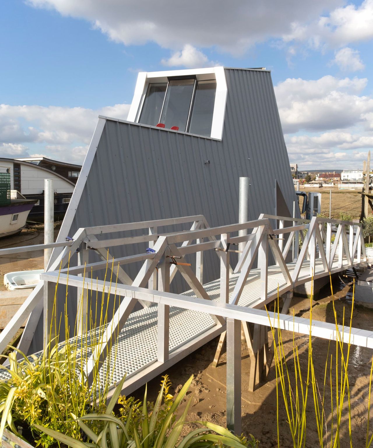 A boat shaped house with a walkway outside