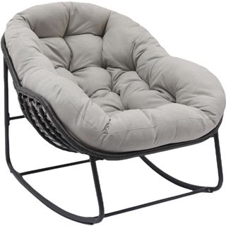 Deeply padded tufted cushion on a reclined rocking chair on black rattan style frame