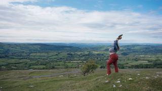 Beautiful woman holding her arms in the air, Black Mountains, Powys, Snowdonia, Wales, UK.