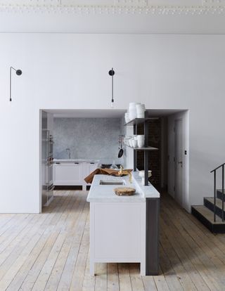 White modern kitchen with wood floor and two-tier island