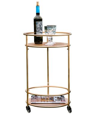 golden colour drinks trolley with drinks and magazine