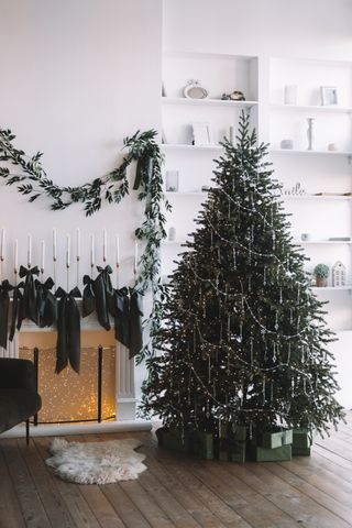 A living room with a Christmas tree and a hanging garland