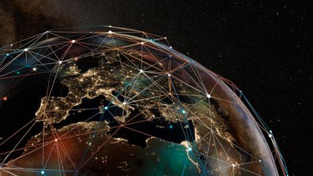 A digital representation of the globe with Europe, Africa and Asia visible and their cities lit up by lights at night. A digital grid above the globe connects countries to one another