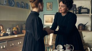 Rose Leslie as Isabella and Keeley Hawes as Cassandra both in black dresses in a kitchen in Miss Austen.