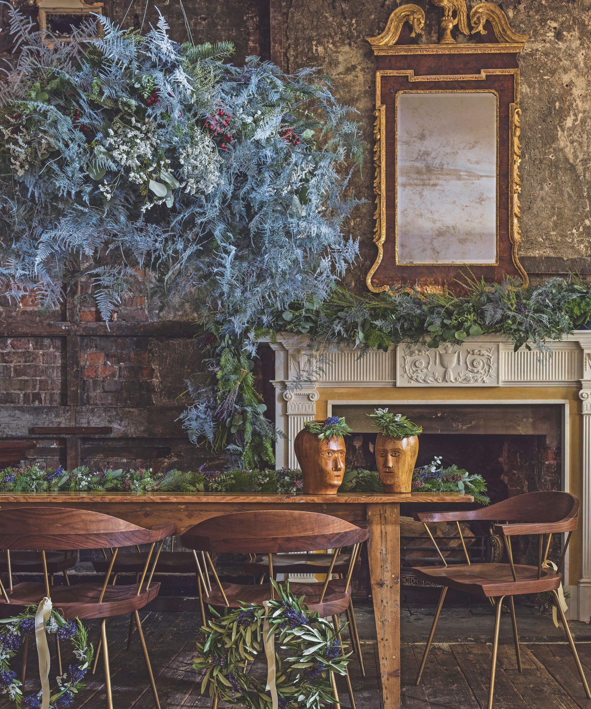 Wooden dining table and chairs with floral garland and wreaths