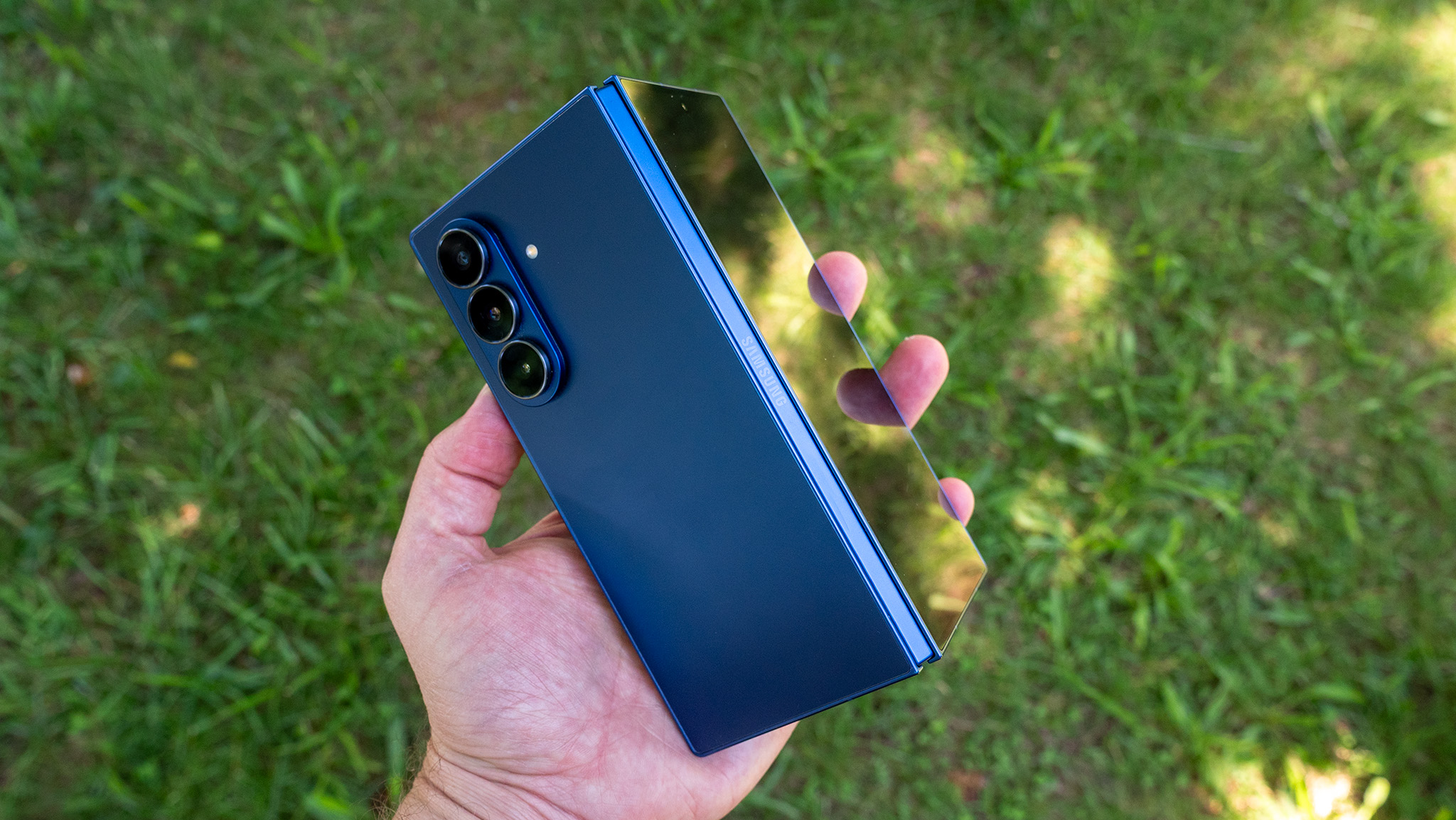 Holding the blue Samsung Galaxy Z Fold 7 while it's tented