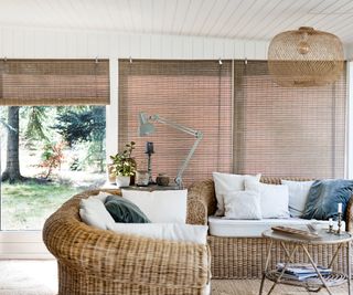 living room extension with natural roller blinds and wicker furniture