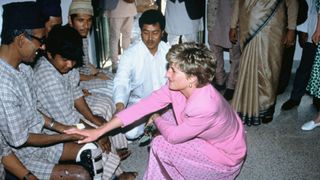 Diana dress all in pink in Bali meeting leoprasy patients, she's holding a mans hand and their smiling at one another