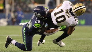 Tre'Quan Smith #10 of the New Orleans Saints is brought down by Ugo Amadi #28 of the Seattle Seahawks during the fourth quarter at Lumen Field on October 25, 2021 in Seattle, Washington.