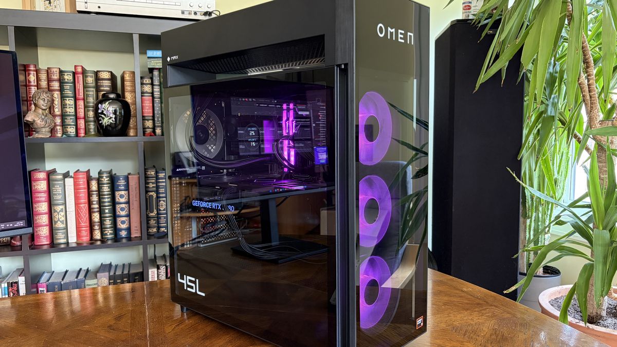 An Omen Max 45L with a transparent side panel displays its internal components, including a GeForce RTX 508 graphics card, against a backdrop of a bookshelf.