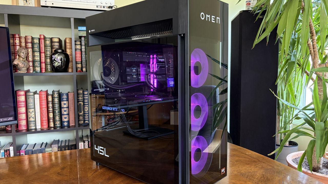 An Omen Max 45L with a transparent side panel displays its internal components, including a GeForce RTX 508 graphics card, against a backdrop of a bookshelf.