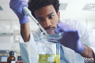 Young scientist working in laboratory, by gremlin