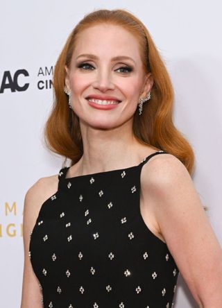 Actress Jessica Chastin wears a strappy black dress with diamond design