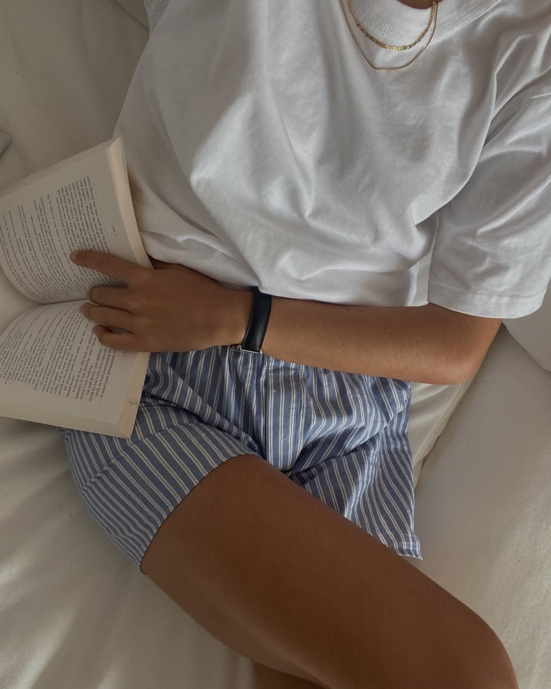 Woman in boxer-style shorts and a white tee