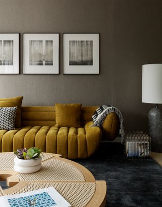 Brown wallpapered living room with yellow velvet sofa