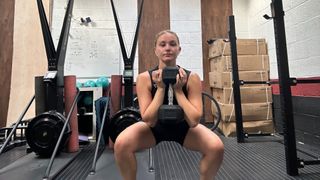 Woman doing a goblet squat with a dumbbell
