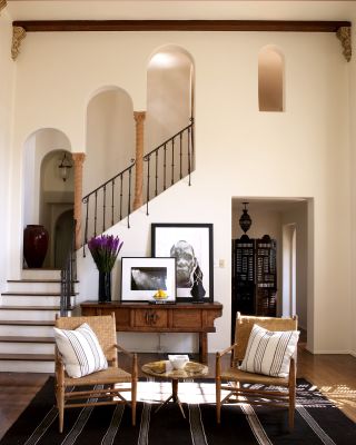 sitting room in cream tones with two rattan chairs and vintage console