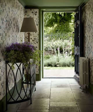 Entryway with floral wallpaper looking out through open front door