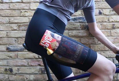 Cyclist in black rapha cargo bib shorts with a copy of Cycling Weekly and a banana in the pocket