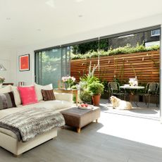 living room with white wall grey flooring and sliding doors to gallery 